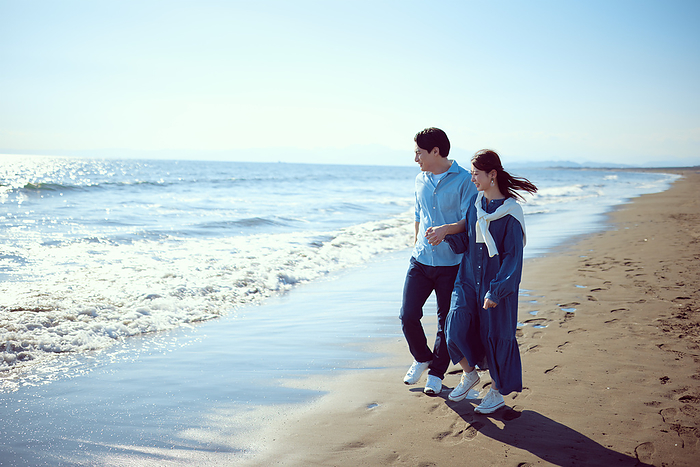 A Japanese couple strolling on the beach