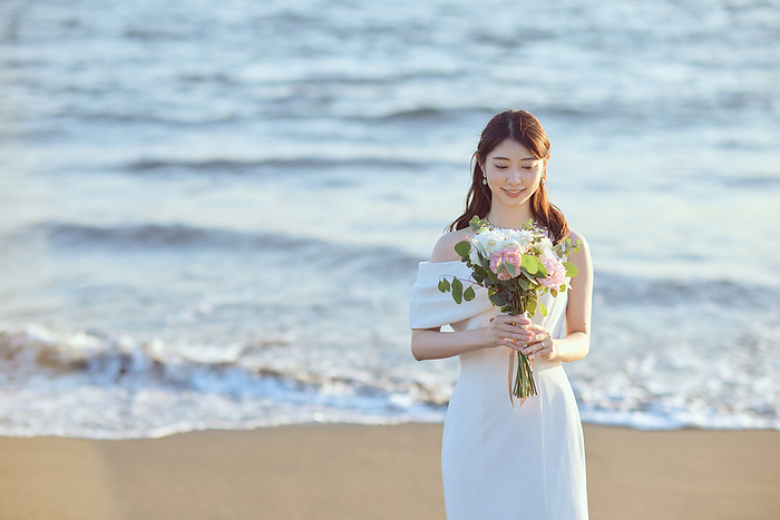 Japanese bride holding her bouquet on the beach