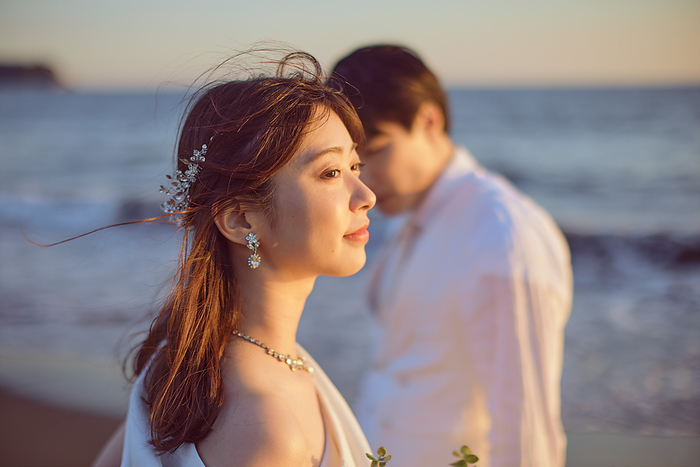 Japanese bride looking far away on the beach