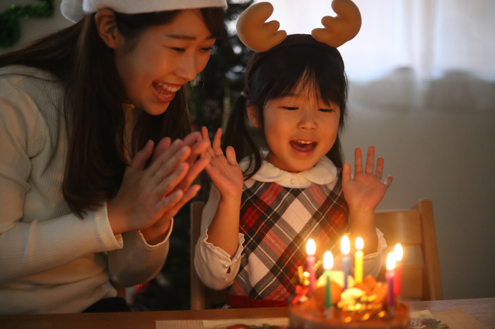 Parents and children blowing out candles