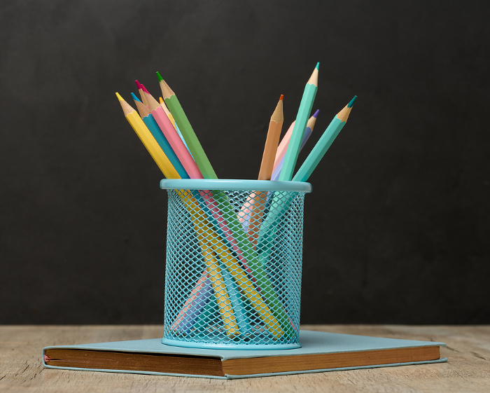 Multi colored wooden pencils on a black chalk board background Multi colored wooden pencils on a black chalk board background