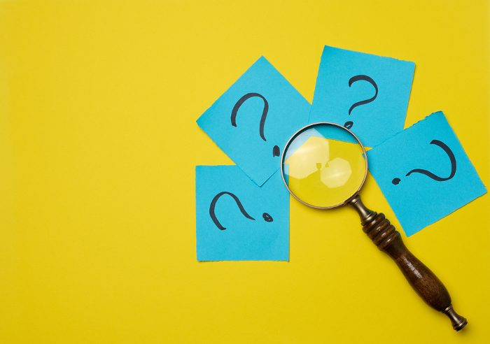 Drawn question marks on stickers and a magnifying glass, yellow background. Searching for truth and answering questions Drawn question marks on stickers and a magnifying glass, yellow background. Searching for truth and answering questions