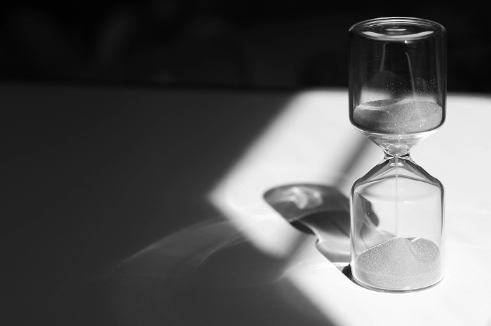 Hourglass on the desk Striking light, shadow and glass reflections