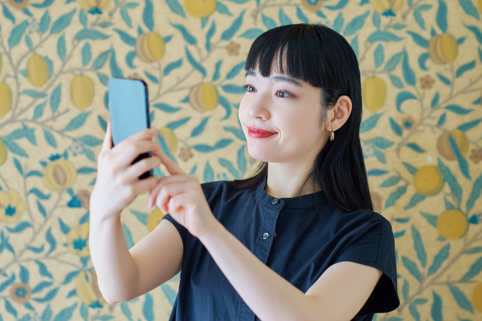Young Japanese woman operating a smartphone (People)