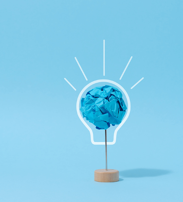 A crumpled ball of blue paper, a drawn electric lamp. New idea concept A crumpled ball of blue paper, a drawn electric lamp. New idea concept