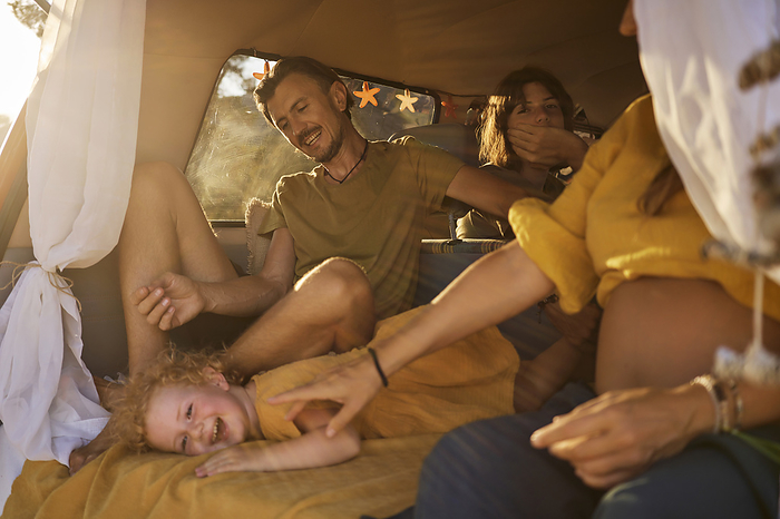 Smiling family spending leisure time together in motor home on vacation