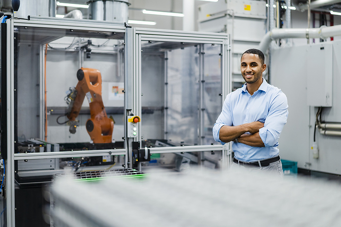 Smiling businessman standing in a factory