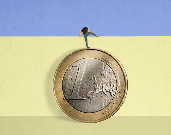 Man standing on oversized Euro coin climbing over wall