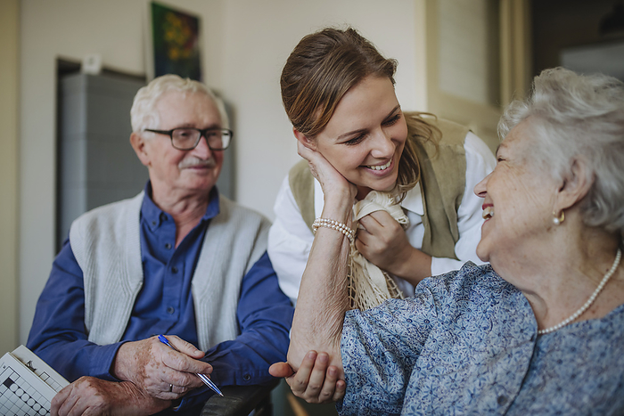 Cheerful senior woman embracing healthcare worker at home