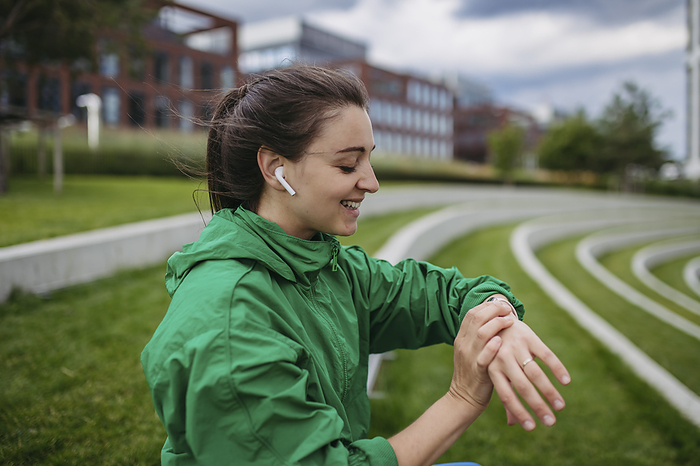 Beautiful woman exercising in a city park checking her performance on smart watch