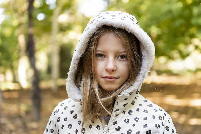 Smiling girl wearing hooded shirt in park