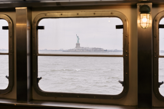 New York cityscape Statue of Liberty seen through window of Staten Island Ferry in Hudson River