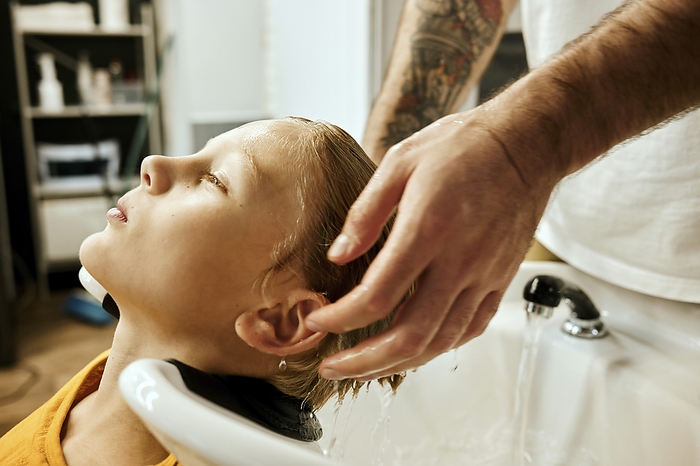 Barber washing customer's hair at salon