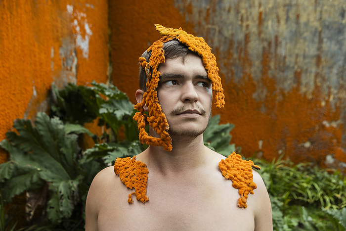 Young man covered in orange moss