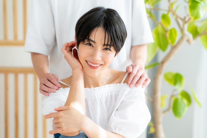 Young Japanese woman with man's hand on her shoulder (People)