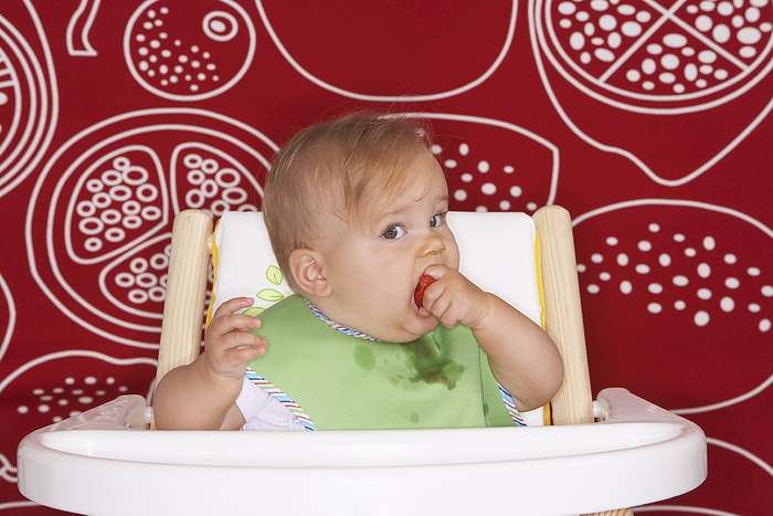 Baby Eating in High Chair, by Masterfile - Radius / Design Pics