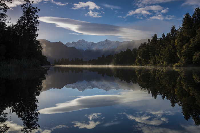 Lake Matheson at sunrise with Mount Cook on right center and Mount Tasman on left center; South Island, New Zealand, by Michael Melford / Design Pics