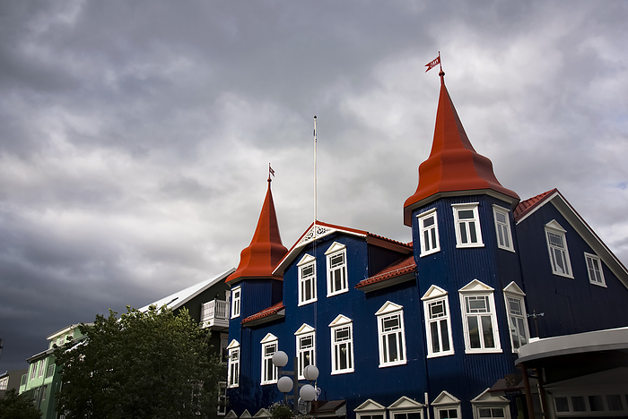 Building with dark blue facade, white window trim and red turrets, in the port town of Akureyri; Akureyri, Iceland, by Michael Melford / Design Pics