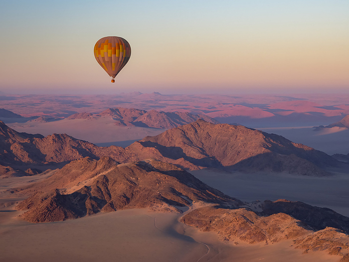 Early morning balloon ride over the sand and mountains in Namib-Naukluft Park; Sossusvlei, Namibia, by Michael Melford / Design Pics