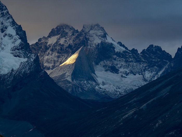 Shaft of light on Paine Grande in Torres del Paine National Park; Patagonia, Chile, by Michael Melford / Design Pics