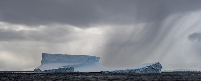 Large iceberg and stormy weather; Antarctica, by Michael Melford / Design Pics