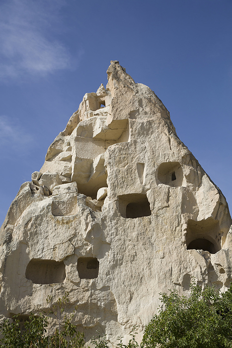 Close-up of Cave Houses carved into pointed rock formations against a bright blue sky near the town of Goreme in Pigeon Valley, Cappadocia Region; Nevsehir Province, Turkey, by Richard Maschmeyer / Design Pics