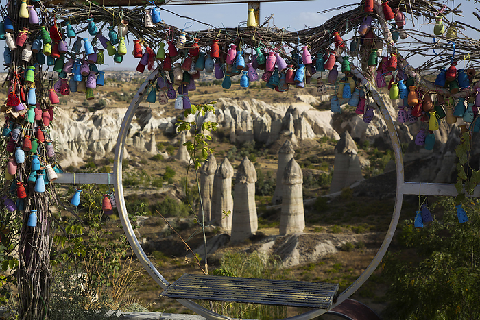 View through a circular swing seat decorated with colorfully painted pottery vases, of the Fairy Chimney rock formations in Love Valley near the town of Goreme, Cappadocia Region; Nevsehir Province, Turkey, by Richard Maschmeyer / Design Pics
