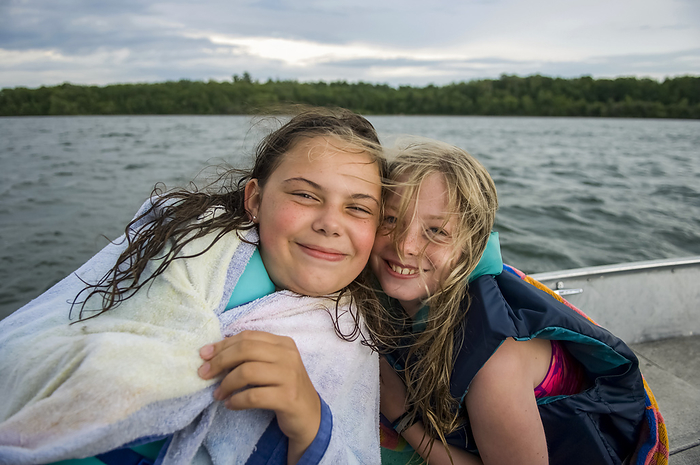 Preteen girls enjoy a boat ride on a lake; Walker, Minnesota, United States of America, by Joel Sartore Photography / Design Pics