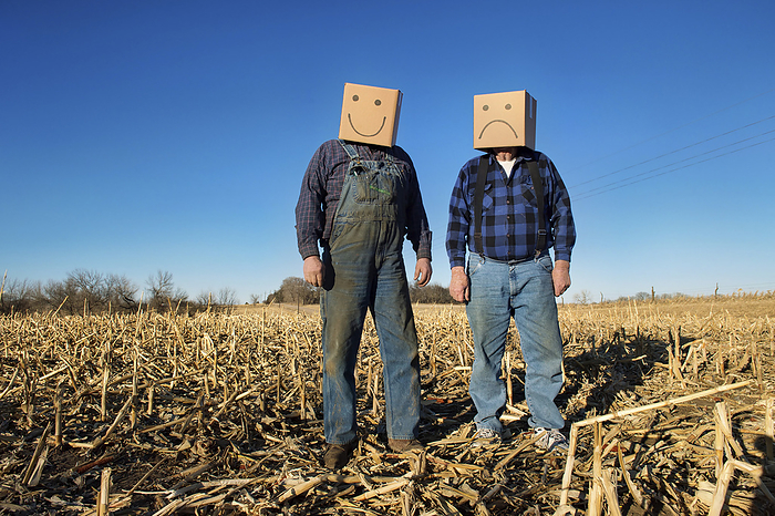 Two farmers wear a happy and an unhappy box head; Lincoln, Nebraska, United States of America, by Joel Sartore Photography / Design Pics