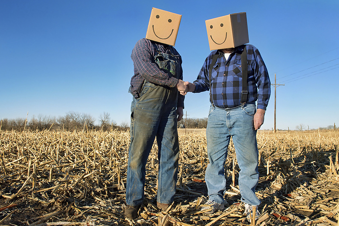 Two farmers with smiling box heads shake hands; Lincoln, Nebraska, United States of America, by Joel Sartore Photography / Design Pics
