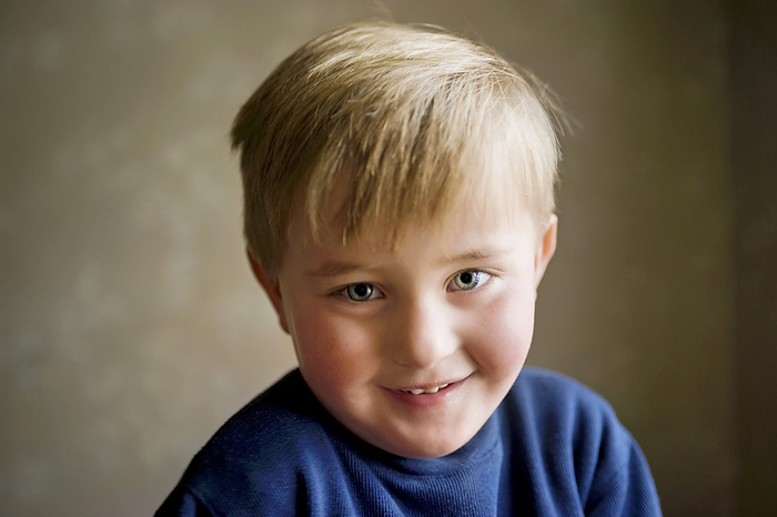 Young boy boy smiling shyly; Studio, by Joel Sartore Photography / Design Pics