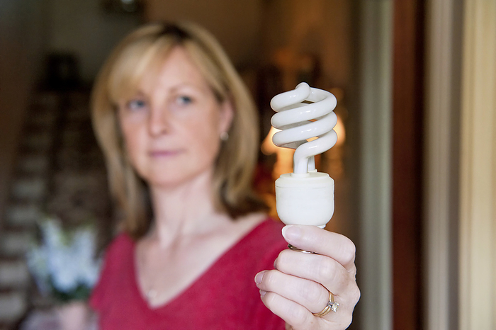 Woman holding an energy saving light bulb; Lincoln, Nebraska, United States of America, by Joel Sartore Photography / Design Pics