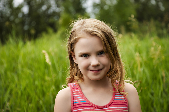 Portrait of a young girl in a park, smiling and looking at the camera; Edmonton, Alberta, Canada, by LJM Photo / Design Pics