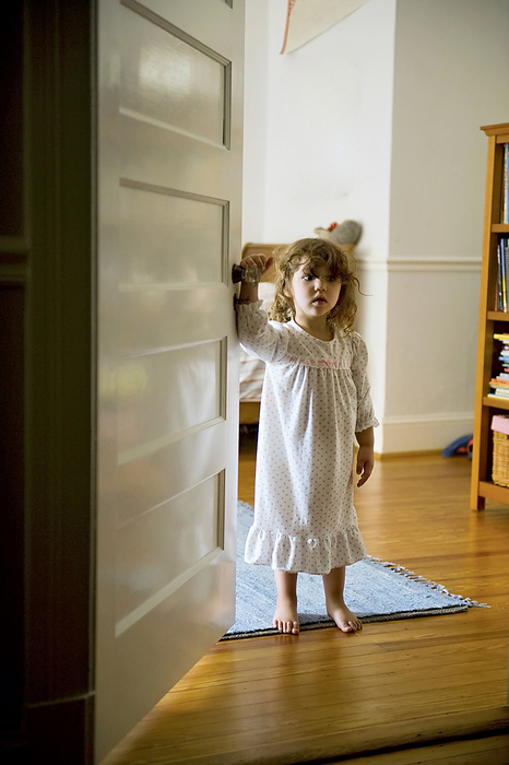 Preschooler girl stands in her bedroom doorway early in the morning; Washington, District of Columbia, United States of America, by Joel Sartore Photography / Design Pics