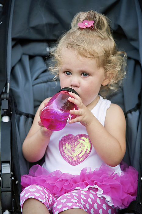 Toddler girl drinks from her sippy cup; Lincoln, Nebraska, United States of America, by Joel Sartore Photography / Design Pics