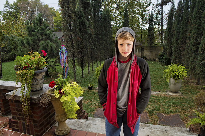 Adolescent boy wears a hooded sweatshirt; Lincoln, Nebraska, United States of America, by Joel Sartore Photography / Design Pics