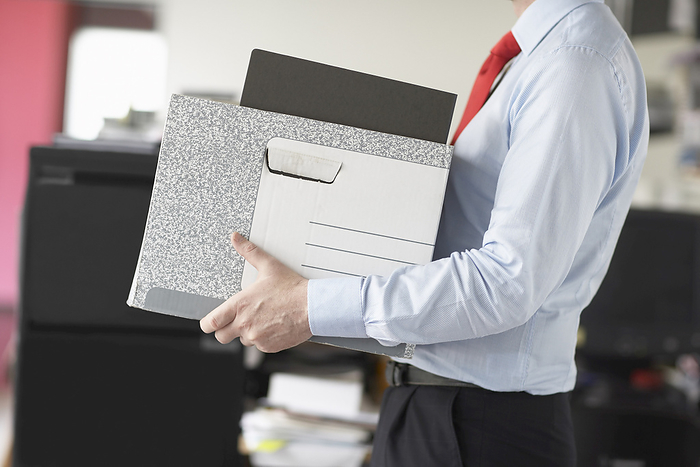 Businessman Carrying Box, by Masterfile / Design Pics
