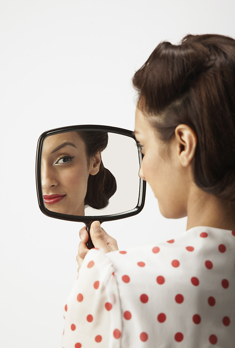 Woman Looking in Mirror, by Masterfile / Design Pics