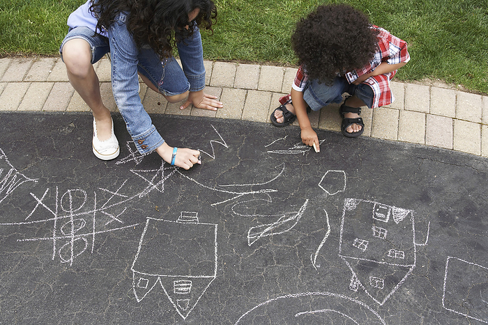 Boy and Girl Drawing with Chalk, by Masterfile / Design Pics