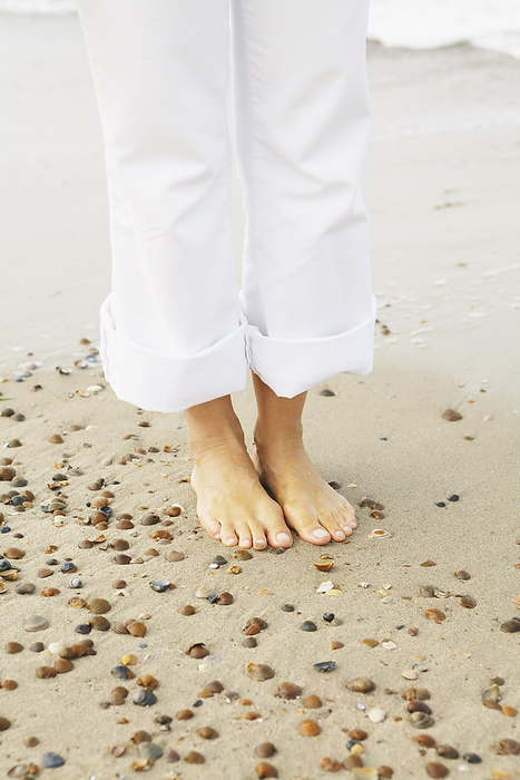 Close-up of Woman's Feet on Beach, by Masterfile / Design Pics