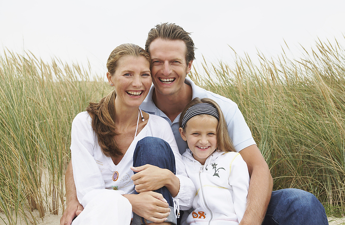 Portrait of Family Sitting on Beach, by Masterfile / Design Pics