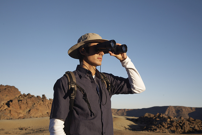 Man Using Binoculars, by Masterfile / Design Pics