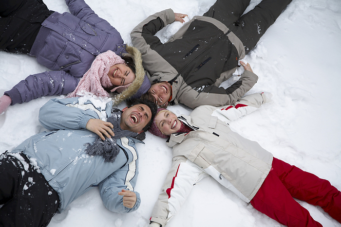 Portrait of Friends Lying in the Snow, by Masterfile / Design Pics