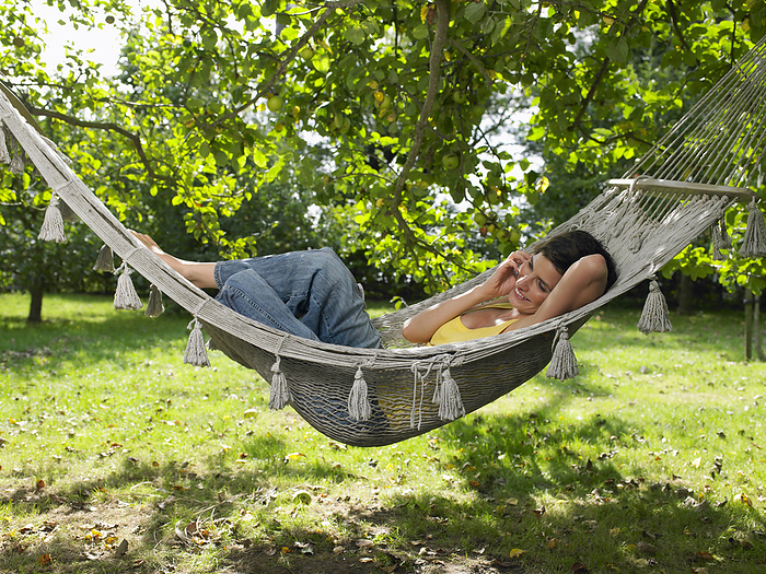 Woman Lying in Hammock, by Masterfile / Design Pics