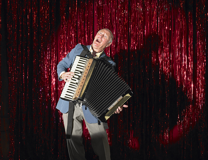 Man Playing Accordion on Stage, by Masterfile / Design Pics