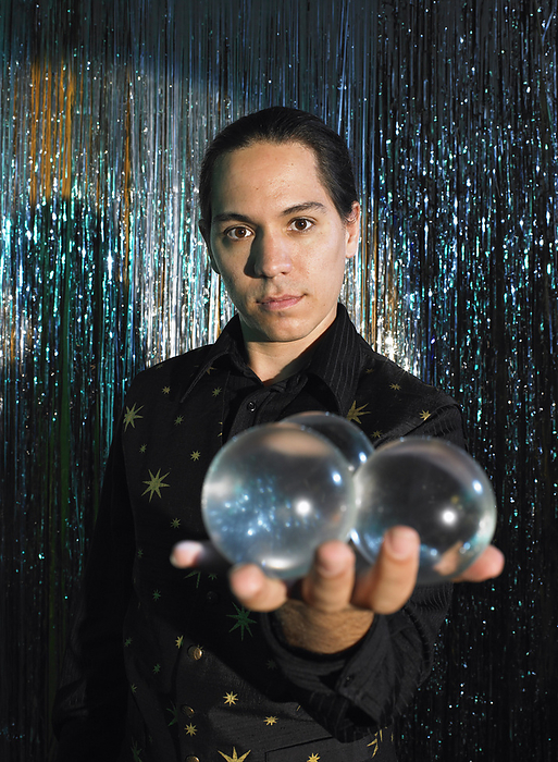 Magician on Stage with Crystal Balls, by Masterfile / Design Pics