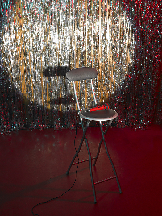 Empty Chair and Microphone on Stage, by Masterfile / Design Pics