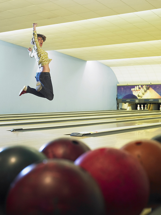 Woman at Bowling Alley, by Masterfile / Design Pics