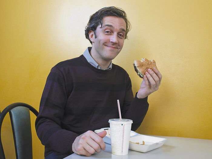 Man Eating Fast Food, by Masterfile / Design Pics