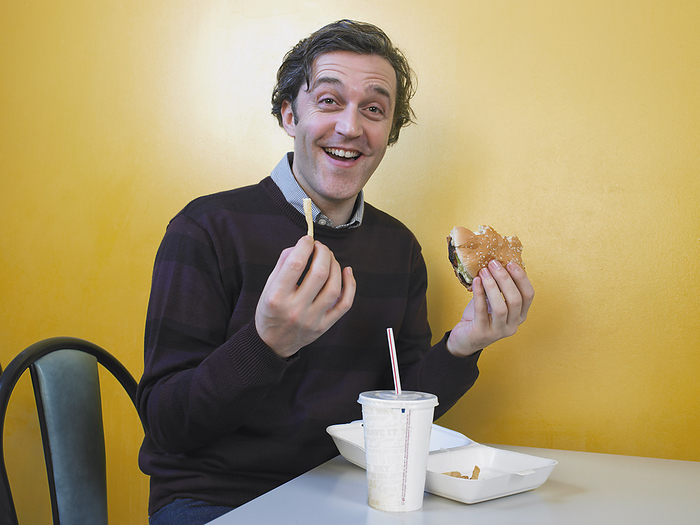 Man Eating Fast Food, by Masterfile / Design Pics